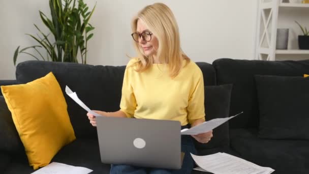 Busy focused mature businesswoman reading and checking papers — стоковое видео