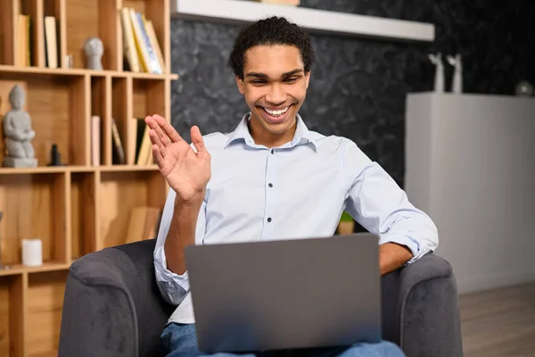 Cheerful African-American male freelancer using laptop computer for video connection — 스톡 사진