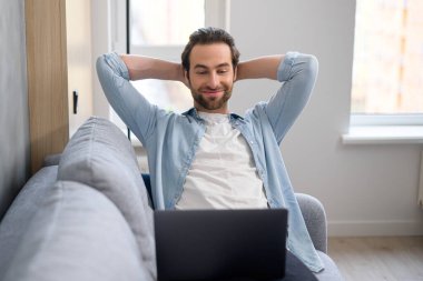 Sakallı yakışıklı genç bir Avrupalı, evinde dizüstü bilgisayarla kanepede oturuyor, interneti arıyor, film ya da seri izliyor, hafta sonları uzaktan görüşme yapıyor, rahatlıyor.