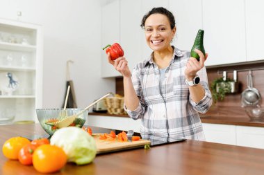 Gülümseyen orta yaşlı kadın sebze pişirmeye gidiyor.