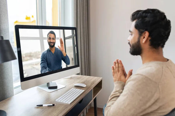 Retrato de homem de cabelos escuros usando computador em casa. Morena empresário masculino olhando para a tela e sorrindo — Fotografia de Stock