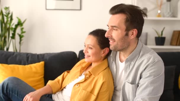 Suave y encantadora pareja de mediana edad enamorada sentada en abrazo en el cómodo sofá — Vídeos de Stock
