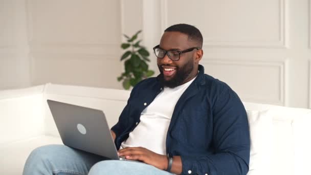 Hilarant homme afro-américain utilisant un ordinateur portable pour la connexion vidéo à distance — Video