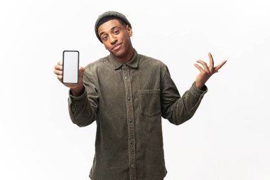 Sıradan tişörtler giyen çekici bir adamın portresi. Akıllı telefonu elinde tutuyor. Hans 'i bir kenara bırakıyor. Beyaz üzerine kapalı stüdyo çekimi.