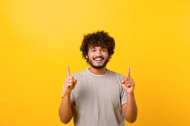 Çekici Hintli adam mutlu yüz ifadesi ile iki parmağıyla işaret ederek, kopya alanı sunuyor.