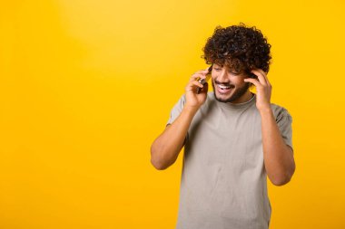 Genç Hintli adam telefonla konuşuyor, planları konuşmak için arıyor, rüya gibi bir yüz ifadesiyle başka yere bakıyor.