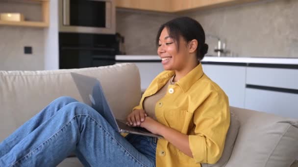 Mujer multiracial vestida con ropa doméstica sentada en la sala de estar — Vídeo de stock