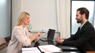 Neşeli genç ve başarılı iş ortakları gülümseyerek el sıkışırlar.