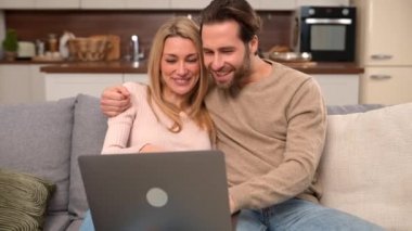 Aşırı mutlu çift boş zamanlarını evde dizüstü bilgisayarla geçiriyorlar.