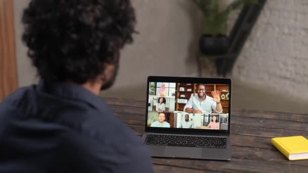 Remote meeting via video call. Indian man sitting in the kitchen and using app — Stockvideo