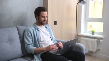 Genç yakışıklı adam video bağlantısı için laptop kullanıyor, gerçek bir arama yapıyor.