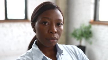 Kameraya bakan, kendinden emin, yüksek yetenekli Afro-Amerikan kadın çalışanın yakın plan portresi.