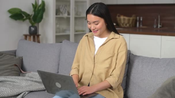 Asiática joven pasando casa ocio con portátil — Vídeos de Stock