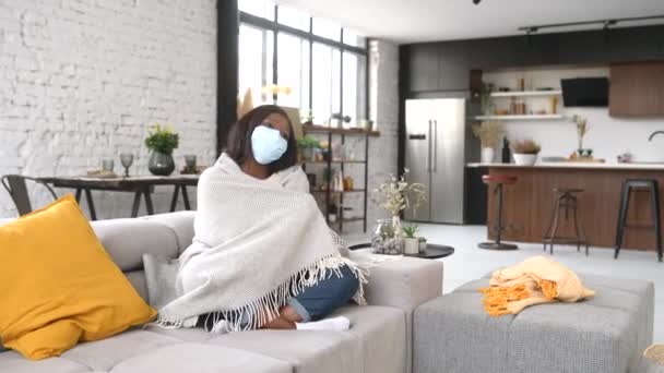 Вид на повну довжину молодої хворої жінки в захисній масці для обличчя, яка почувається погано вдома — стокове відео