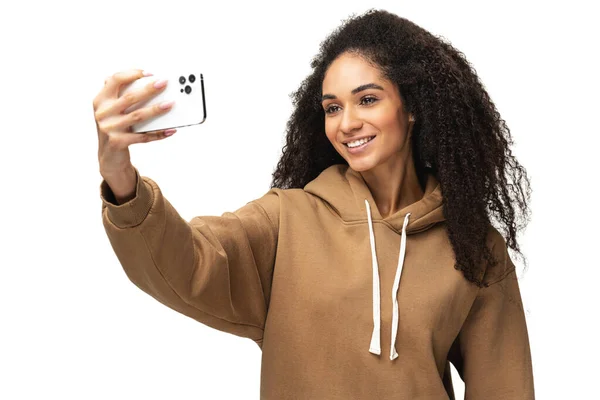 Glad bekymmerslös afroamerikansk ung kvinna med lockigt hår tar selfie — Stockfoto