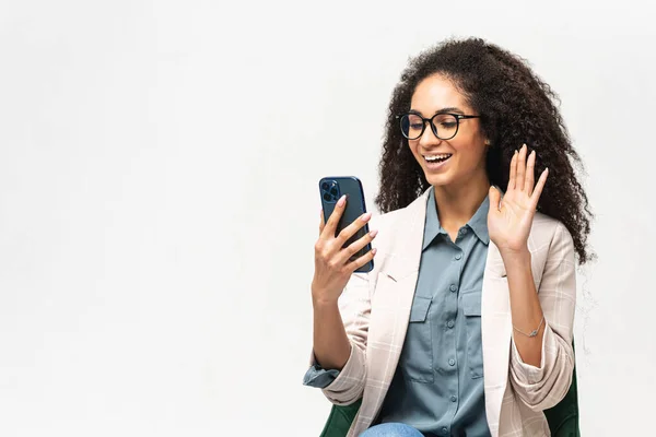 Positiv smart ung afro-amerikansk kvinnlig frilansare eller student som använder smartphone för videoanslutning — Stockfoto