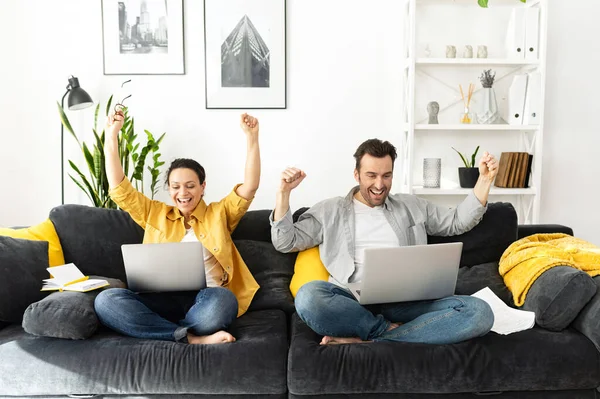Woman and her man in front of laptop, rejoicing at their success. Cheerful couple won the lottery, bought a vacation ticket — Fotografia de Stock