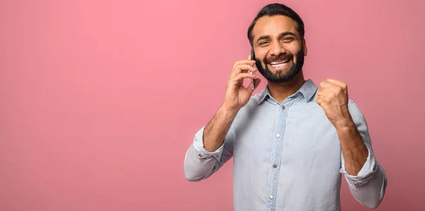 在粉色背景下被隔离在电话里的印度快乐男人 — 图库照片