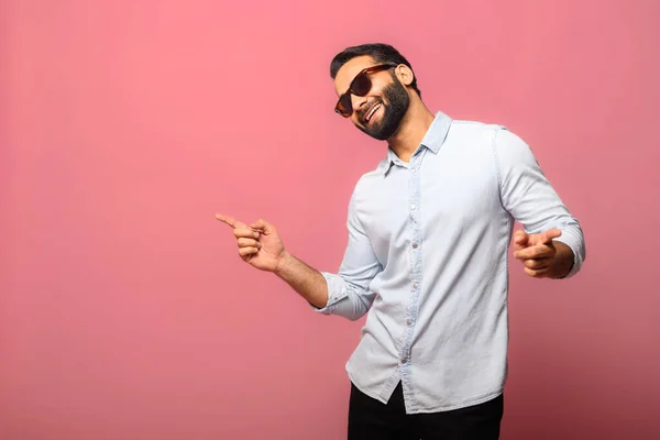 Overjoyed Indian man wearing sunglasses dancing, makes movements to music — Stock Photo, Image