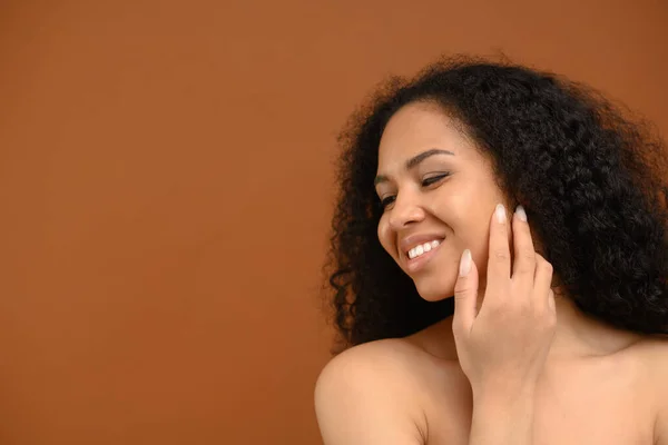 Splendida giovane afro donna in posa in studio su sfondo marrone — Foto Stock
