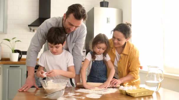 Glückliche vierköpfige Familie kocht gemeinsam in der Küche — Stockvideo