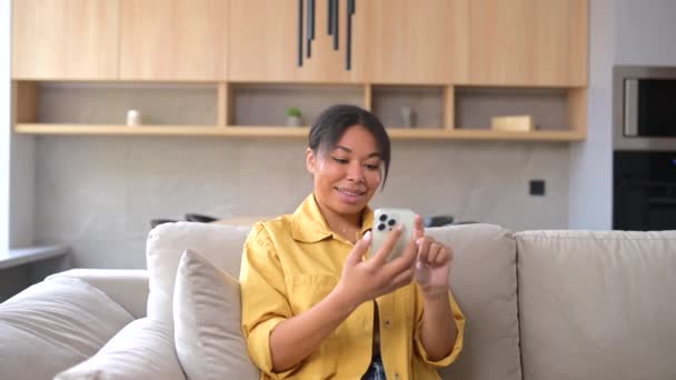 被石头砸死的非洲裔美国女士手持智能手机，看着屏幕，举起拳头 — 图库视频影像