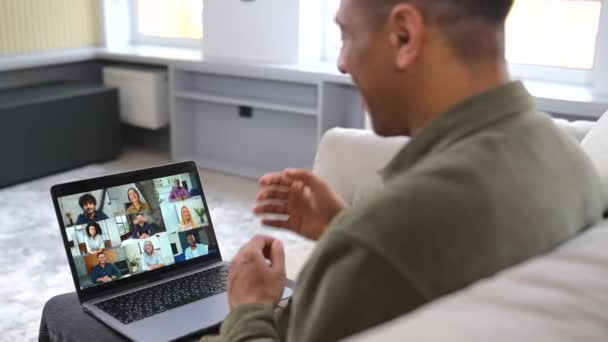 Vista cortada do homem multirracial usando laptop moderno para chamada de vídeo com muitos interlocutor — Vídeo de Stock