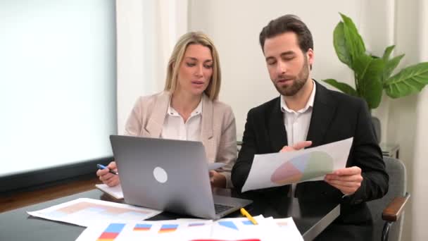 Muž obchodník mluví se svou kolegyní v kanceláři, zatímco drží dokumenty. — Stock video