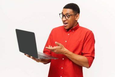 Kırmızı gömlekli ve gözlüklü, dizüstü bilgisayar ekranına bakan Afro-Amerikan yakışıklı girişimci.