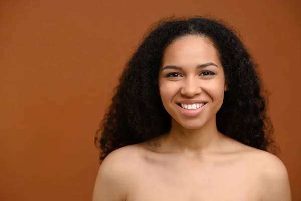 Portrait of charming multiracial lady standing against brown wall. Natural beauty — Foto Stock