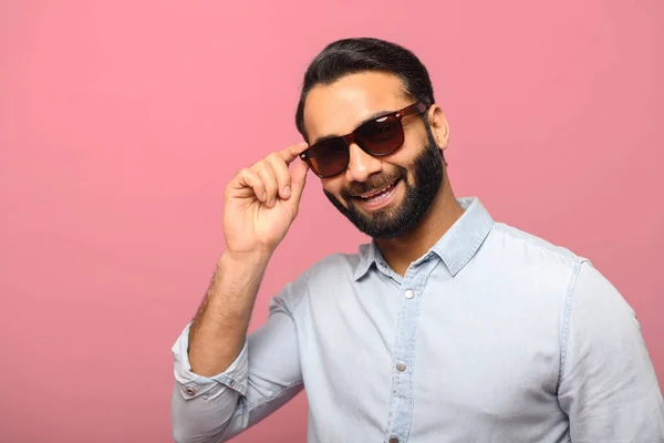 Headshot of handsome positive bearded man wearing sunglasses and blue casual shirt — Stock Photo, Image