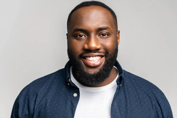 Friendly and positive African-American guy wearing shirt over t-shirt looks at camera — Stockfoto