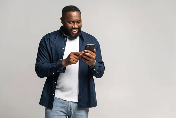 Black guy chatting online, using new mobile app, full length — Stockfoto