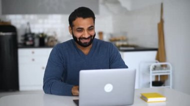 Genç Hintli erkek çalışan, iş arkadaşlarıyla sanal görüşme için video bağlantısı kullanıyor.