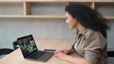 Video chat with employees. African-American woman on online meeting with many people together