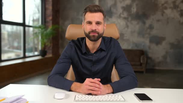 Молодий бородатий впевнений підприємець в діловому повсякденному одязі дивиться на камеру — стокове відео