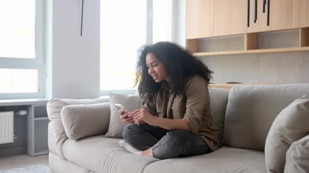 Multiracial woman looking at the camera and holding smartphone in her hands. — Stock video