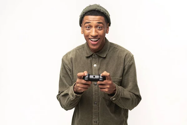 Jeune homme multiracial excité jouant à des jeux vidéo et regardant la caméra, tenant la console de joystick sans fil isolée sur fond blanc — Photo