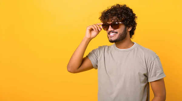 Élégant beau indien jeune bouclé homme portant casual t-shirt et lunettes de soleil — Photo