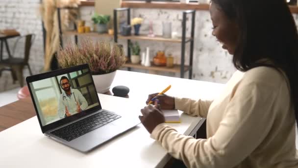 Mujer afroamericana hablando en línea desde casa con un médico, teniendo un chequeo médico virtual — Vídeos de Stock