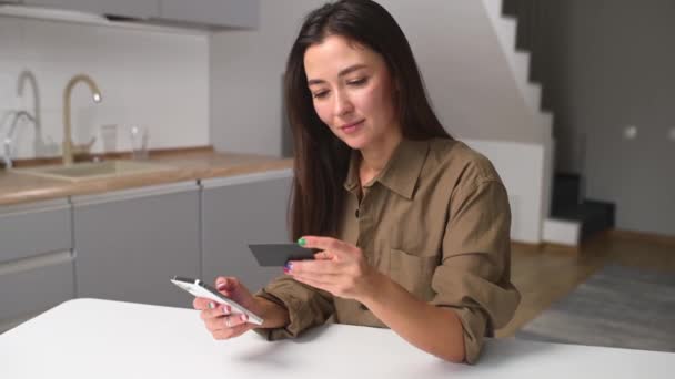 Emocionado asiático mujer compras en línea sentado con tarjeta de crédito en casa — Vídeo de stock