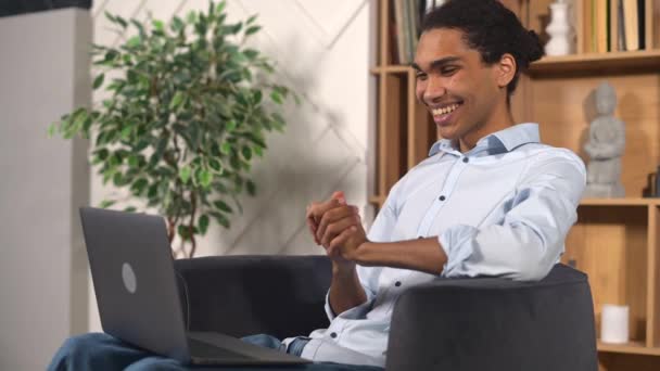 Alegre afroamericano freelancer masculino utilizando el ordenador portátil para la conexión de vídeo — Vídeo de stock