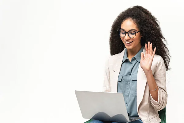 Femme multiraciale confiante dans l'usure intelligente à l'aide d'un ordinateur portable isolé sur fond blanc. Employée de bureau ou étudiante saluant à l'écran — Photo