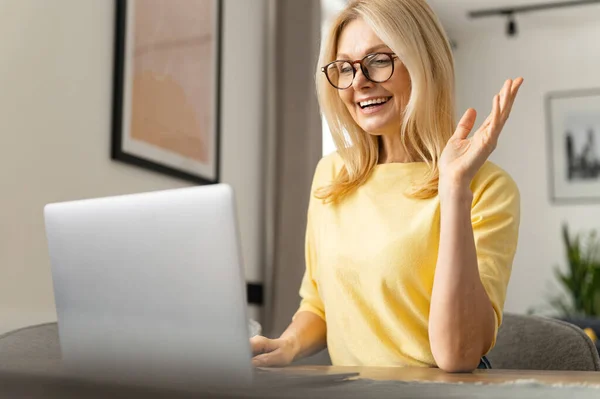 Happy young nice woman looking at the laptop screen, holding video call meeting conversation, discussing working issues, passing job interview from home — Photo