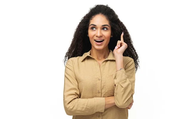 Happy young multiracial curly smiling woman 20s holding index finger up in sign of great solution, african-american female came up with great new idea isolated on white — Stock Photo, Image