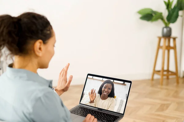 Nahaufnahme einer Frau mit langen Haaren per App für die Videokommunikation mit Kollegen, Freunden, Online-Treffen, Blicken und Winken am Laptop-Desktop — Stockfoto