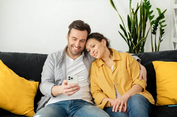 Casal Alegre Abraçando Passando Tempo Com Smartphone Casa Esposa Marido — Fotografia de Stock