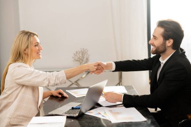 Sağlam bir anlaşma. Minnettarlıkla el sıkışmanın yan görüntüsü. Erkek ve kadın ortaklık adına el sıkışıyor. Stok fotoğrafı