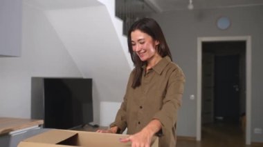Tatmin olmuş stil sahibi Asyalı kadın paket kutusunu açıyor, hediyeleri açıyor, online bir mağazadan sipariş edilen ürünleri merak ediyor, hızlı teslimat ve sevkiyattan memnun bayan müşteriler.