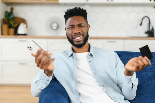 Confuso Confundido Homem Multirracial Camisa Casual Inteligente Segurando Smartphone Cartão — Fotografia de Stock